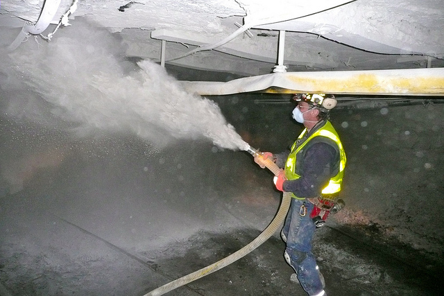 A West Virginia Coal Miner sprays rock dust
