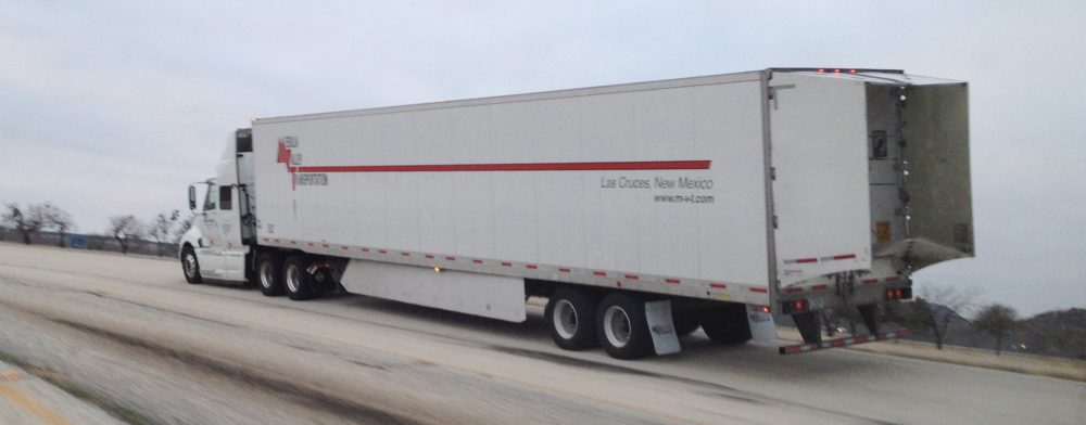 Tractor-trailer with a trailer skirt and boat-tail, saving fuel and reducing emissions