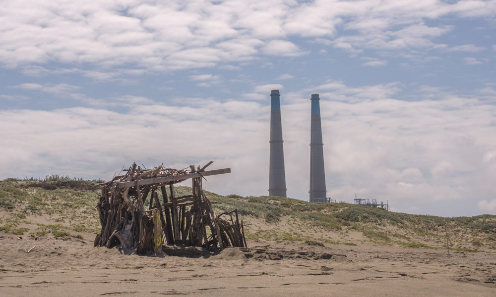 Moss Landing Power Plant stacks visible behind the dunes.