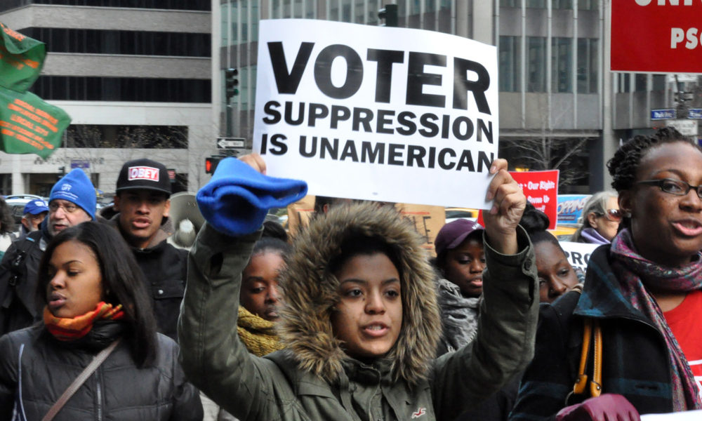 Black woman holding up sign at voting rights march