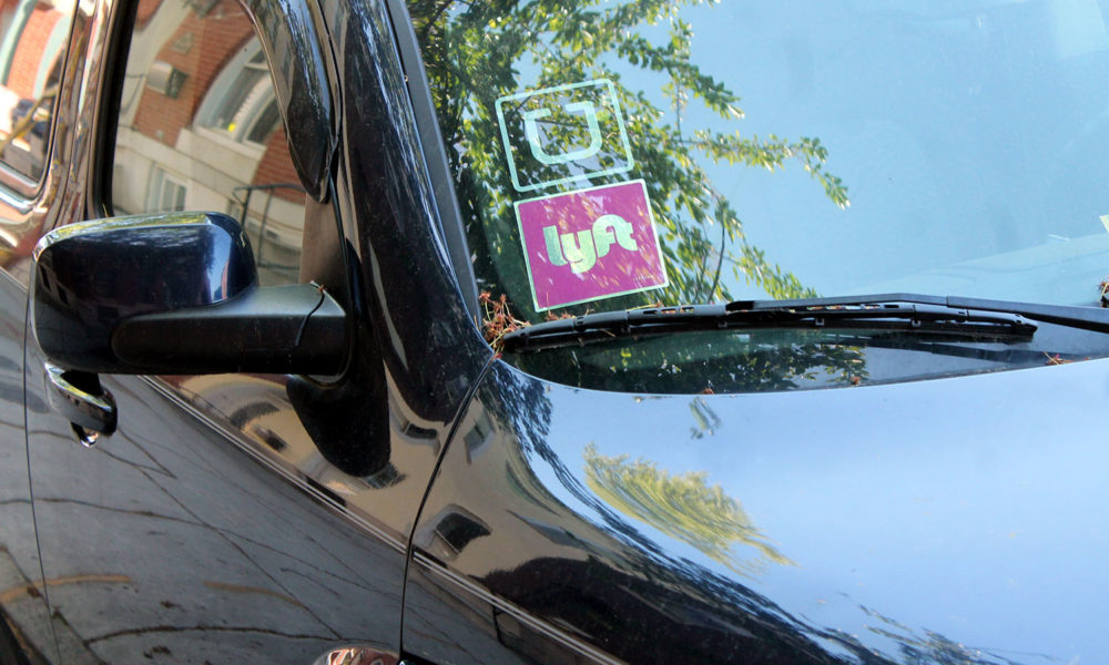 A car windshield with Uber and Lyft stickers