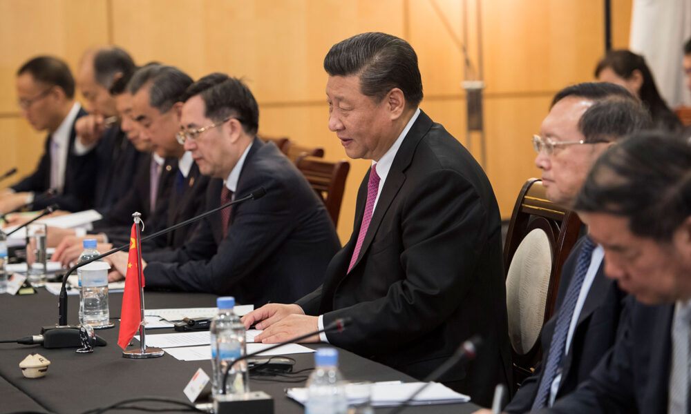 Chinese President Xi Jinping seated at table during talks|