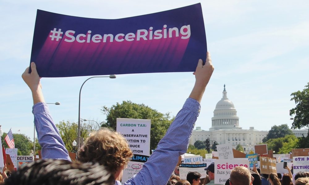 Science Rising sign held up at a march with the US Capitol in the background.