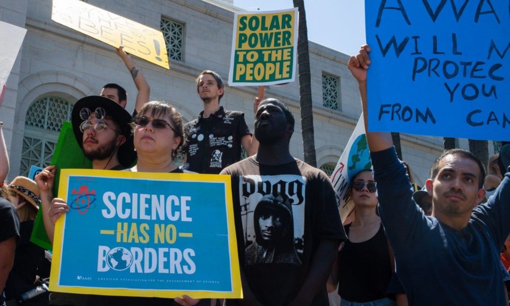 Marchers hold signs including one reading "science has no borders" at the Los Angeles march for science in 2017
