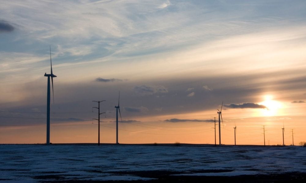A shot of some wind turbines at the Central Illinois Wind Farm, on a cold winter evening at sunset, with snow visible around the turbines