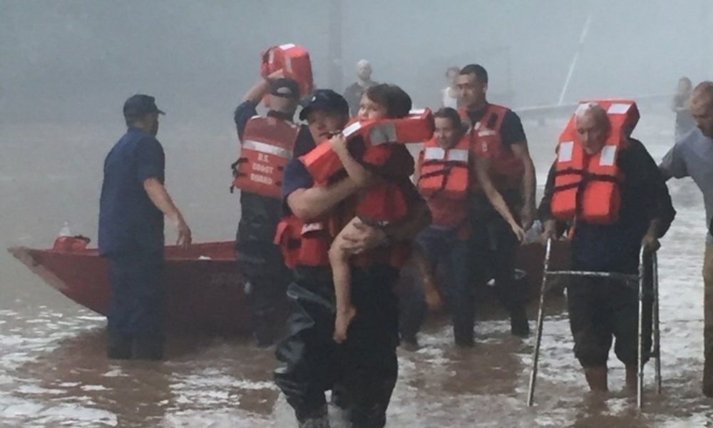 US Coast Guard members provide life vests to West Virginia residents affected by a flood.
