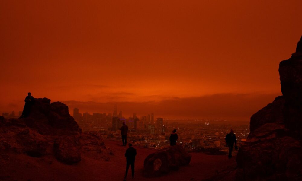 Silhouettes of people overlooking San Francisco after wildfires turned the sky an eerie orange in 2020
