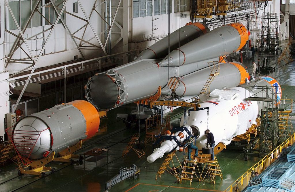 This picture shows a Soyuz rocket being prepared for launch. The object in the lower left corner is the third stage of the launcher. 
