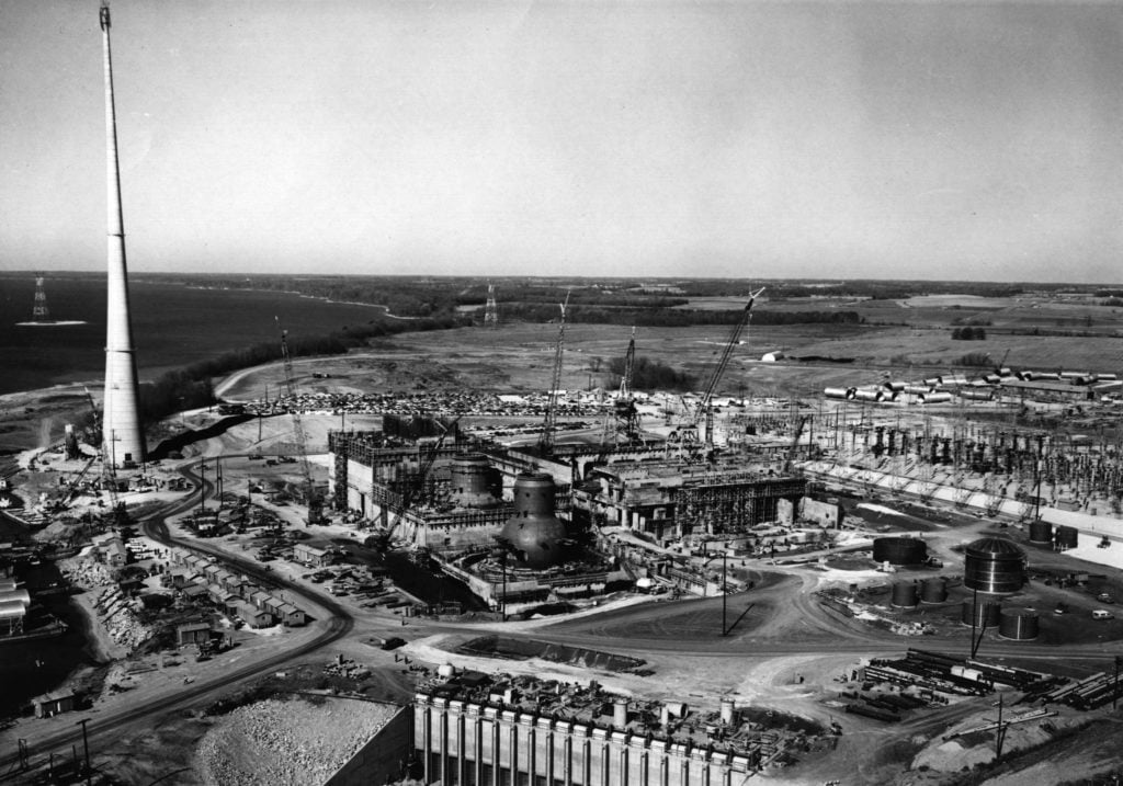 Fig. 1. Browns Ferry under construction in late 1969 with the Unit 1, Unit 2, and Unit 2 reactor buildings left to right in the center of the picture with the stack to the left. 