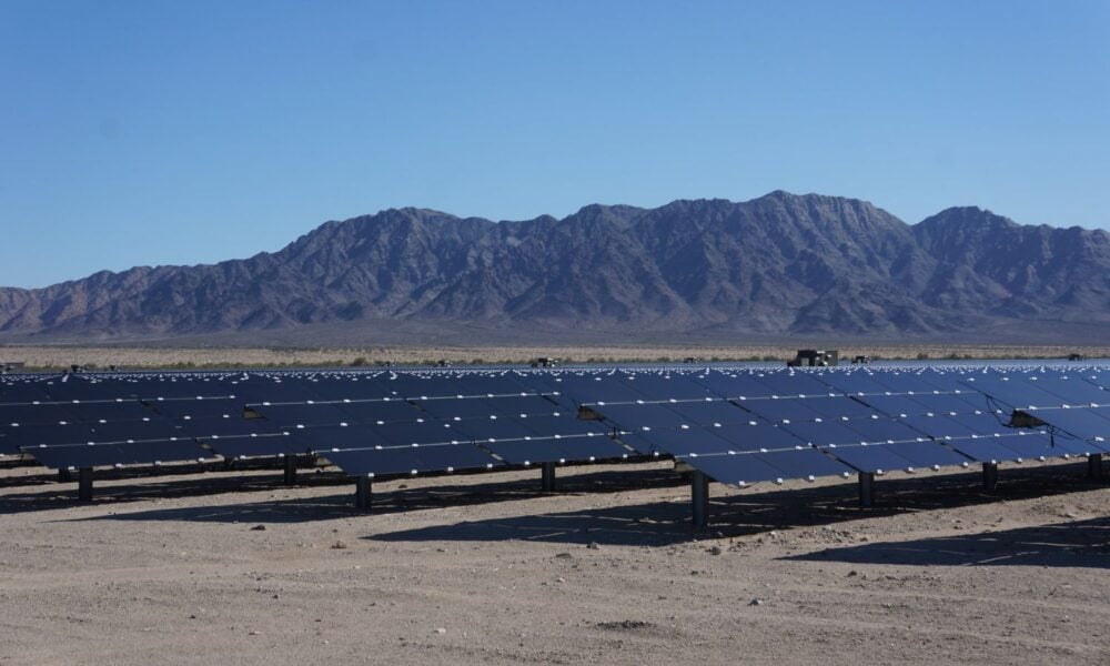 row of solar panels with mountain backdrop