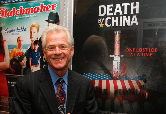 Dr. Peter Navarro pictured next to a poster advertising a film based on his book: Death by China. 