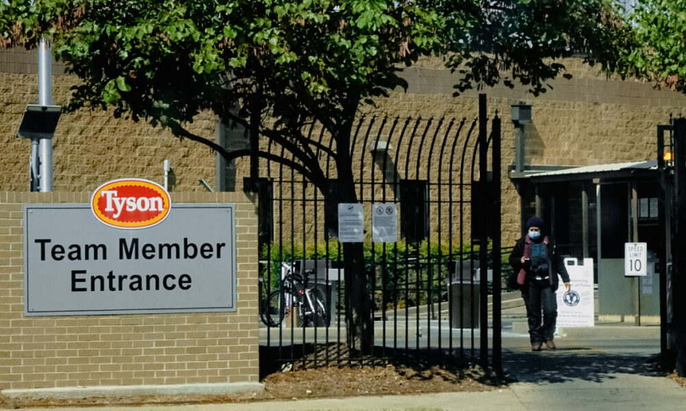 photo of an employee walking through a gate labeled "Tyson Team Member Entrance"