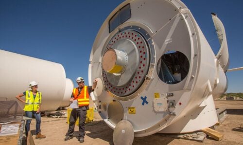 A land-based wind turbine nacelle being is prepared for installation. 