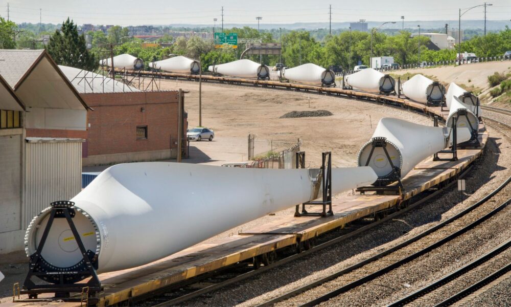 Wind turbine blades being transported by train through Denver.