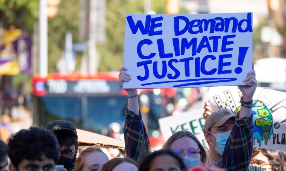 A protestor holds up a sign reading "we demand climate justice" at a Climate Strike and march in Pittsburgh on 9/24/21.