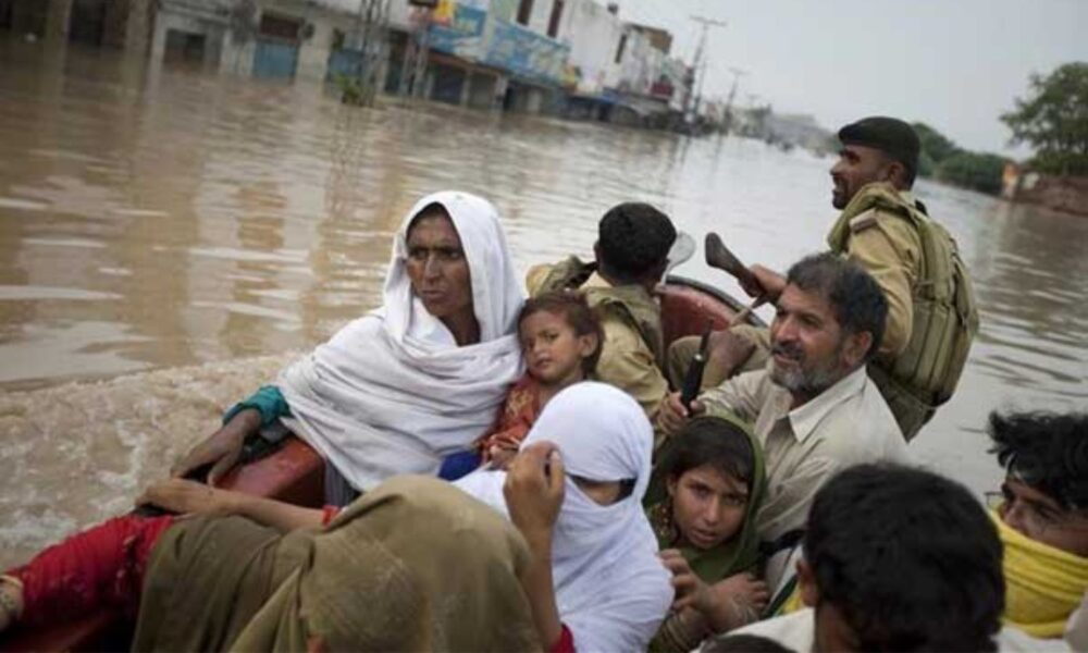 Soldiers evacuate a family in a boat along the main road in Nowshera, Pakistan, as the road is flooded