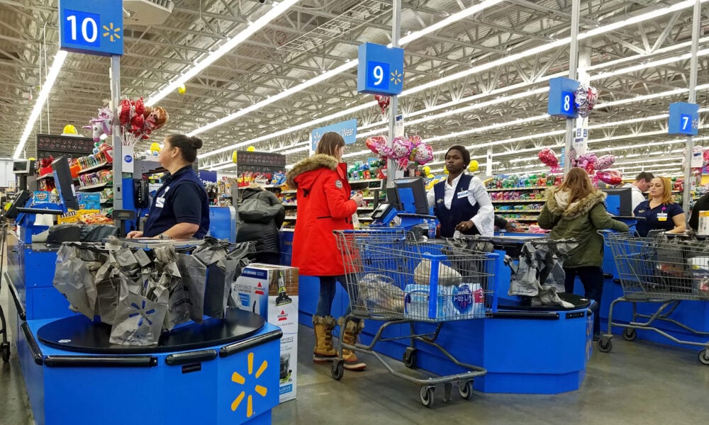 photo of cashiers and customers in several checkout lines at a Walmart store