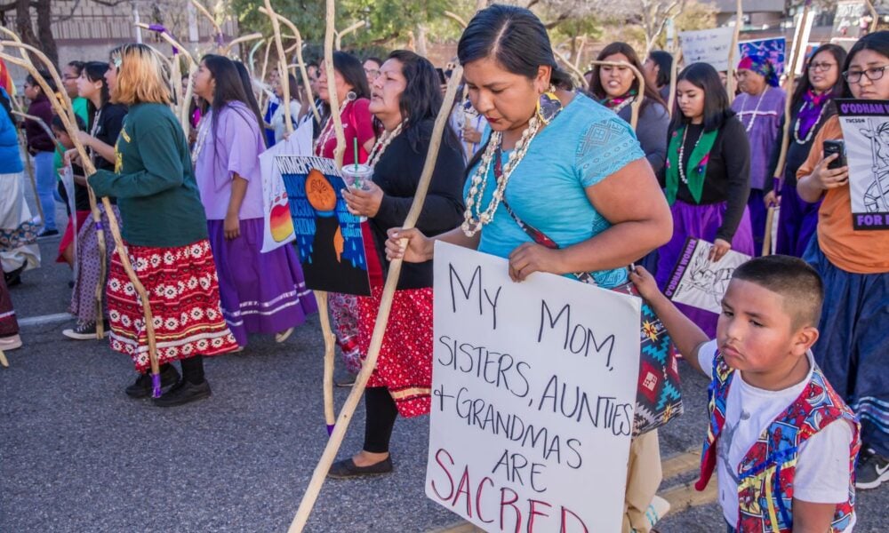Tohono Indian Women led the Tucson 2019 Women’s March with a show of strength, resilience and power. This woman’s sign said: My Mom, Sisters, Aunties and Grandmas are sacred. Her son was by her side. International Women’s Day
