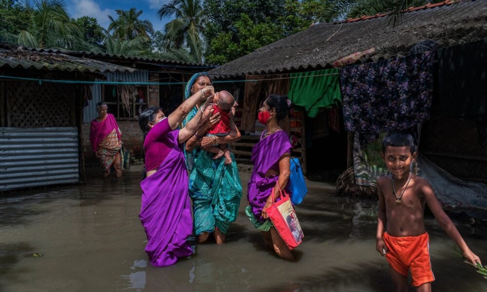Women with kids in a flooded village