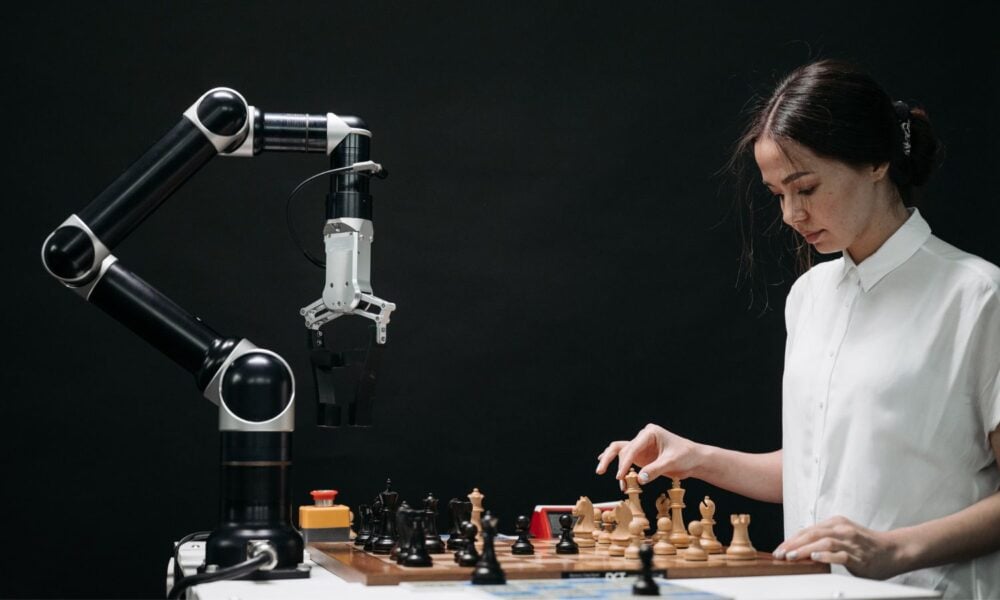 women playing chess with a computer/robot arm