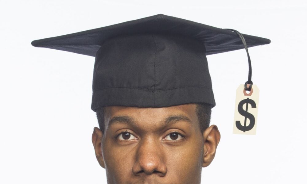 black graduate with dollar sign on cap and gown