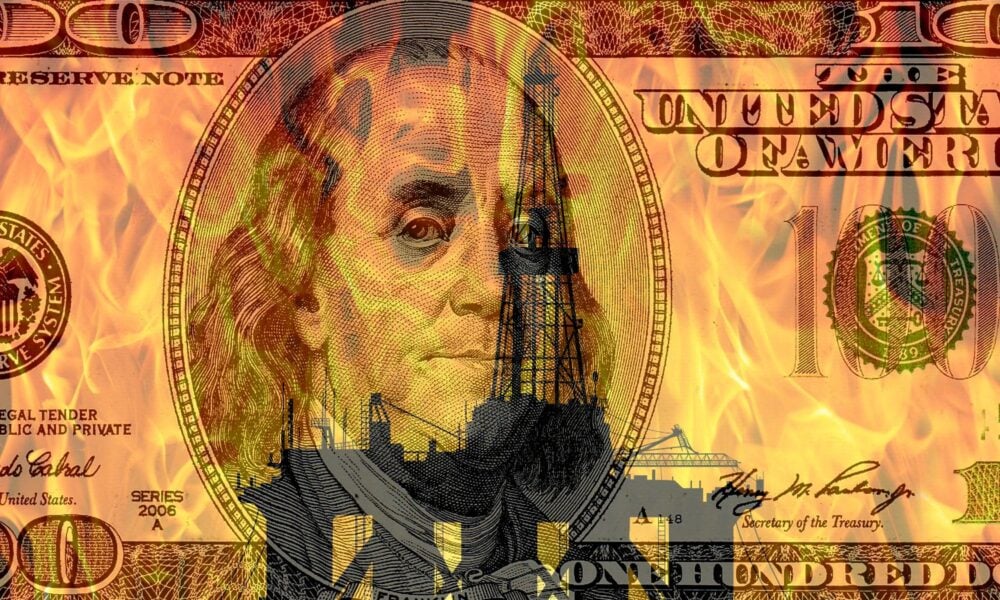100 dollar bill over burning oil rig