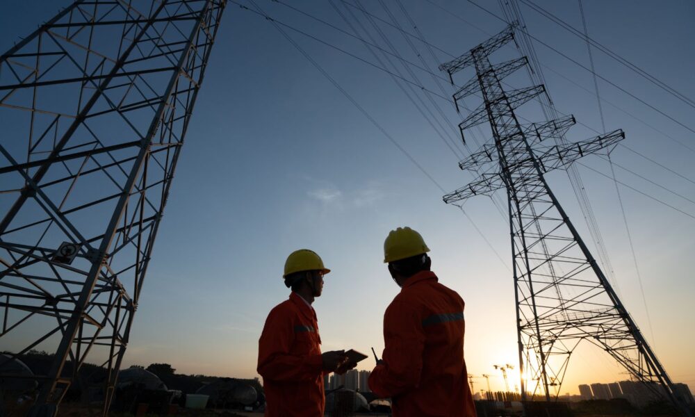 two workers and an electricity transmission line