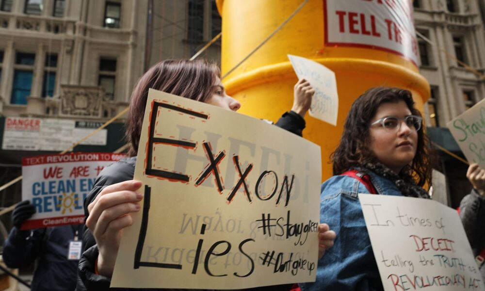 Activists rally outside of the then-State Attorney General's office to support a New York state investigation into whether the oil giant Exxon covered up its knowledge about climate change. The foremost sign reads "Exxon Lies."