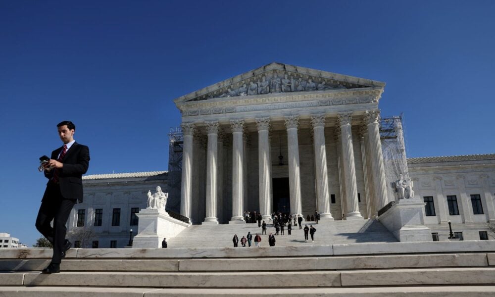 Against the backdrop of a blue sky, people head down the stairs outside of the U.S. Supreme Court on February 21, 2024 in Washington, DC.