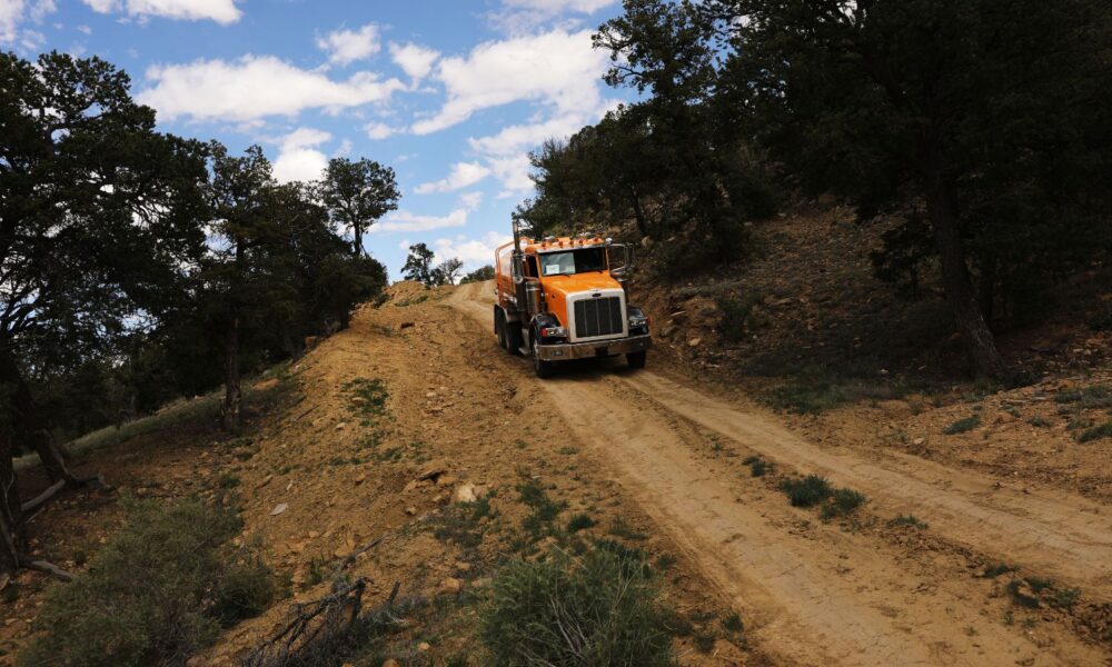A member of Navajo Nation/the Diné people drives a water truck on a dirt road to deliver water to her community, in 2019 in Thoreau, New Mexico.