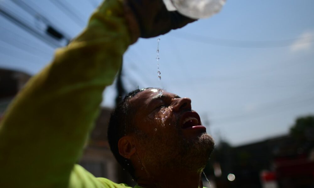 Construction worker Felipe Campuzano pours water on his face to cool off as he digs a sanitation pipe ditch during a heatwave on August 4, 2022 in Philadelphia, Pennsylvania.