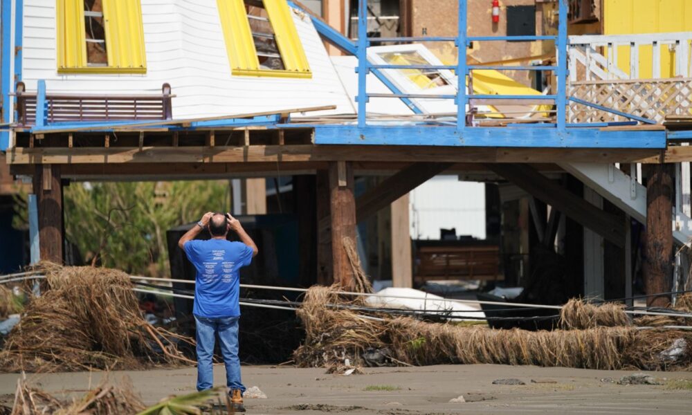 A man documents storm damage to a house after Hurricane Ida on September 3, 2021 in Grand Isle, Louisiana.