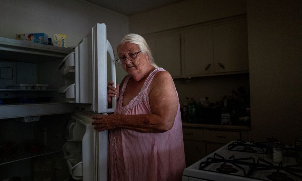 Woman opening empty refrigerator after Hurricane Beryl knocks out power to region.