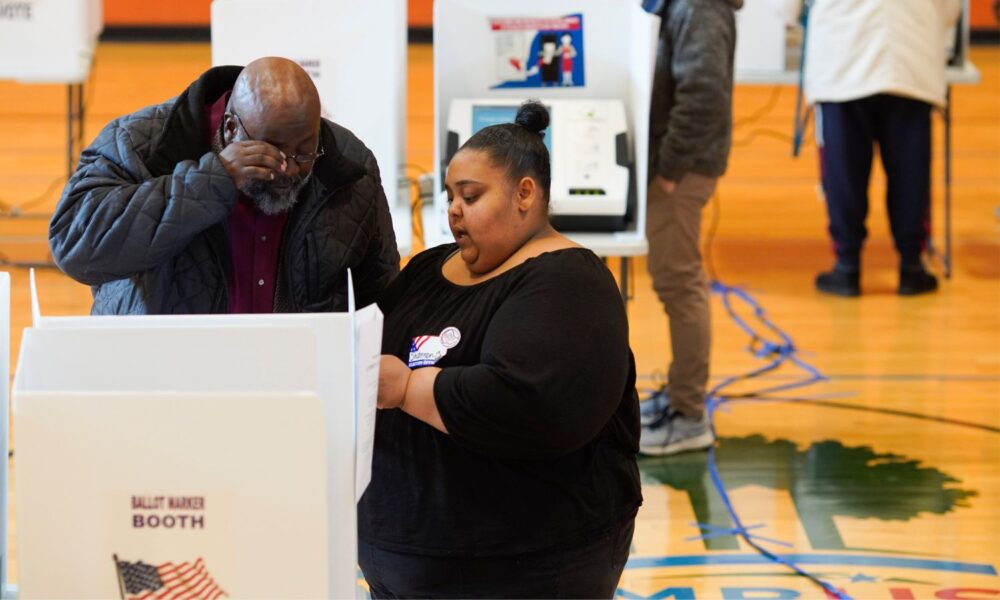 A poll worker helps a voter.