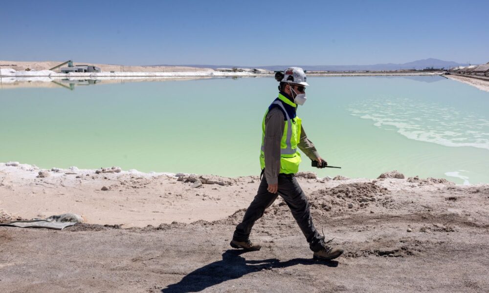 A lithium mine supervisor inspects an evaporation pond of lithium-rich brine in the Atacama Desert in Salar de Atacama, Chile.