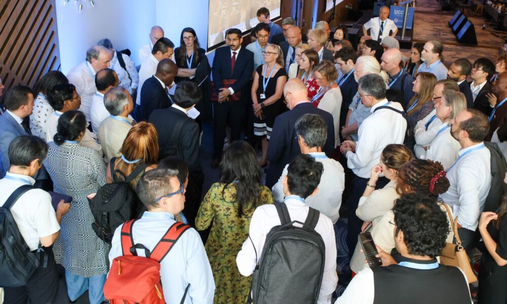 Delegates to the 61st IPCC session convene in a huddle at the end of the afternoon plenary session.