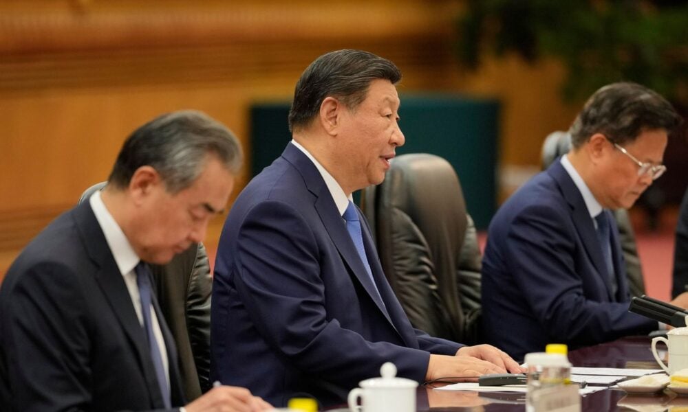 Chinese President Xi Jinping (center) and his delegation, including Foreign Minister Wang Yi (left), attend a meeting.