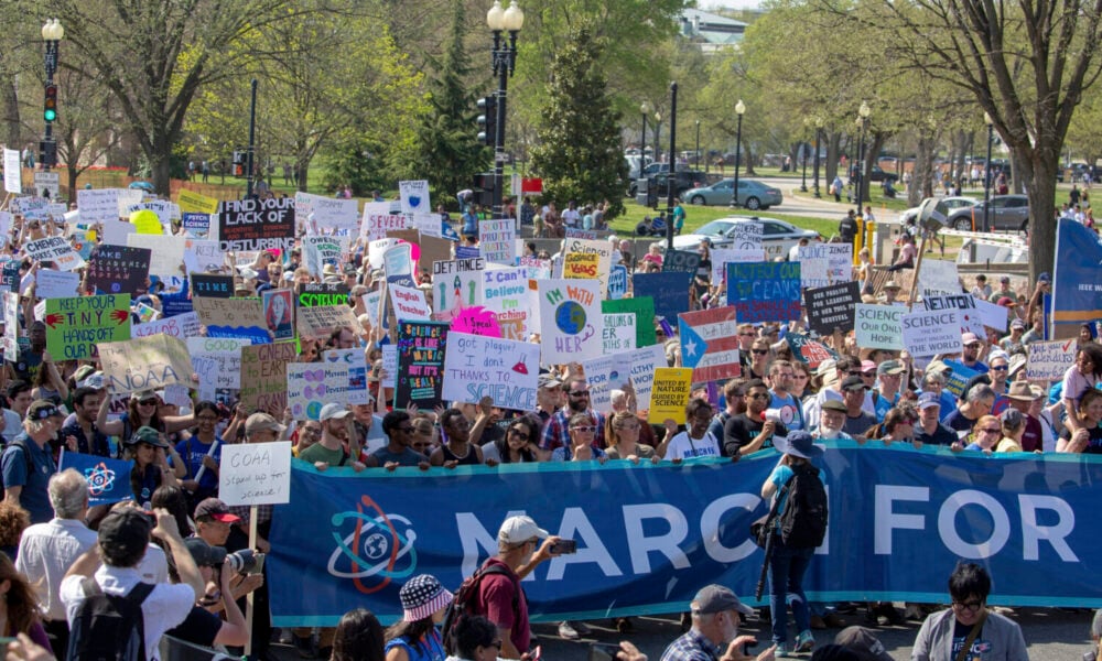 a crowd holding signs at the 2018 March for Science